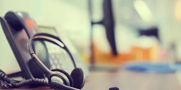 Professional office workspace featuring a headset and telephone for effective communication.