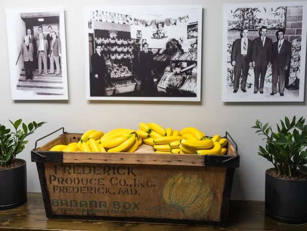 Vintage wooden banana box filled with bright bananas, surrounded by nostalgic black-and-white photos.